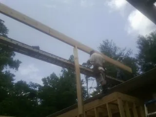 Carpenter setting a ridge beam over a new addition frame — Ice Dam Removal by Roofing Brothers in Westphalia